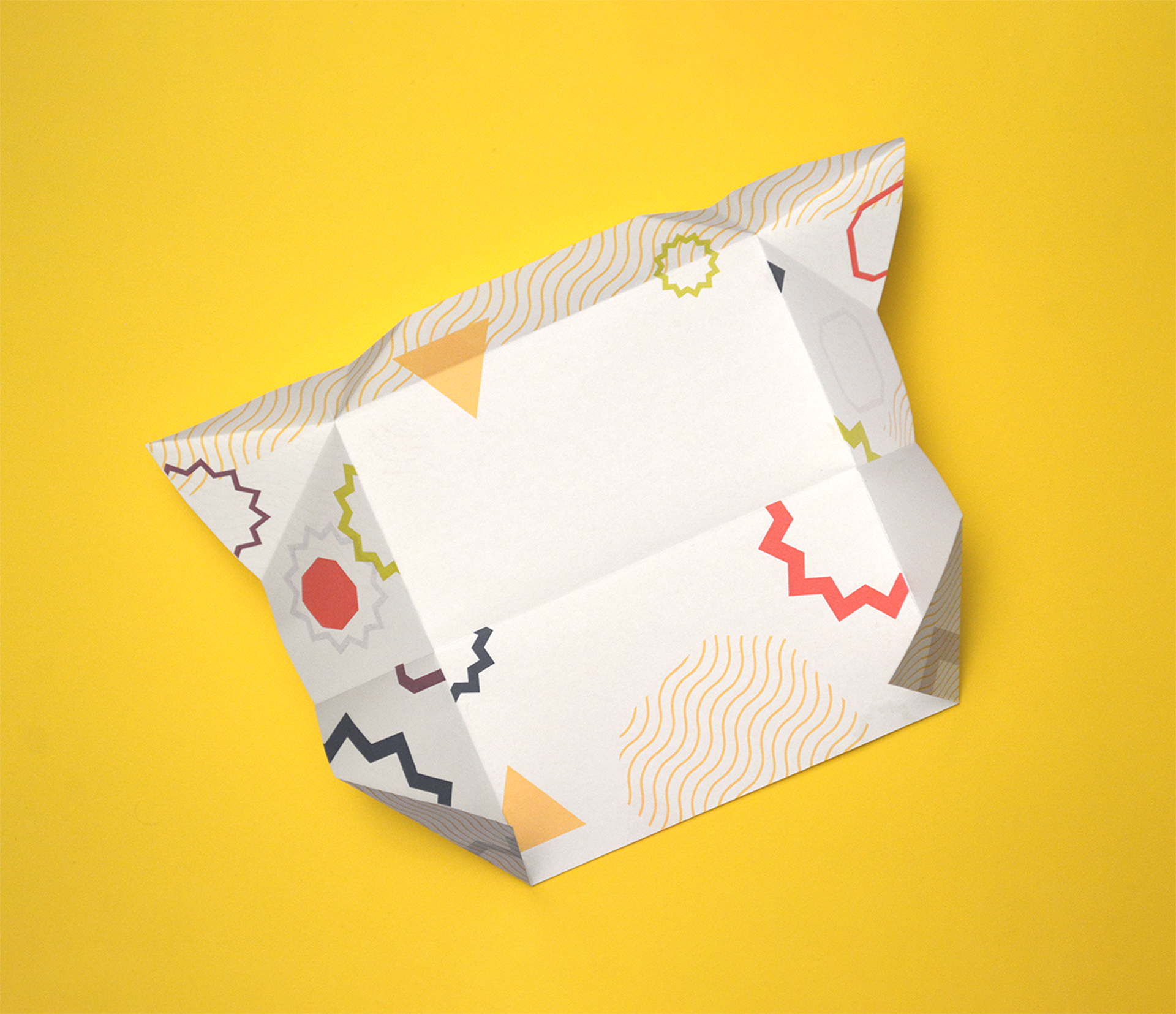 An envelope with funky designs is laid out on a yellow background.